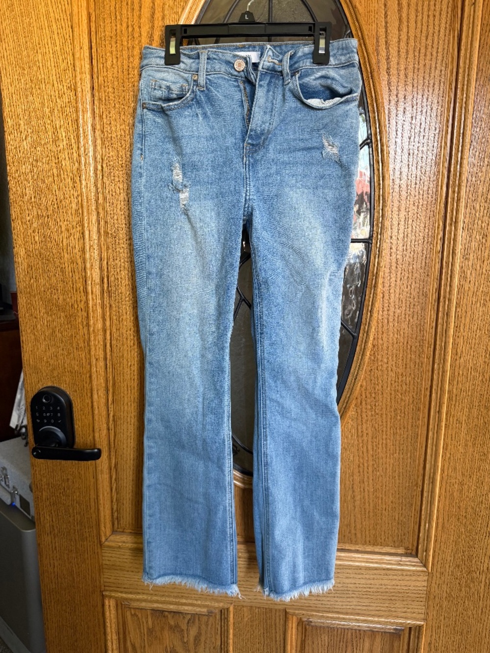 Light wash blue denim jeans with frayed hem, size: 27